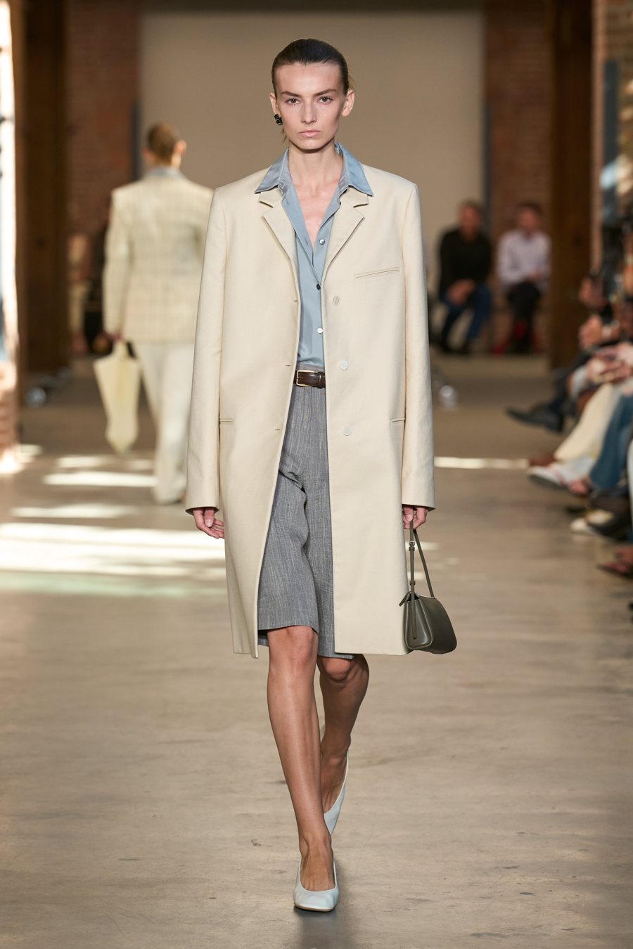 Calvin Klein Collection весна-лето 2027, образ 23: пальто цвета слоновой кости поверх серых шорт