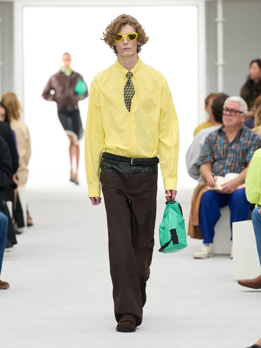 Loewe весна-лето 2027, образ 8: жёлтая рубашка, галстук и коричневые брюки, зелёная сумка