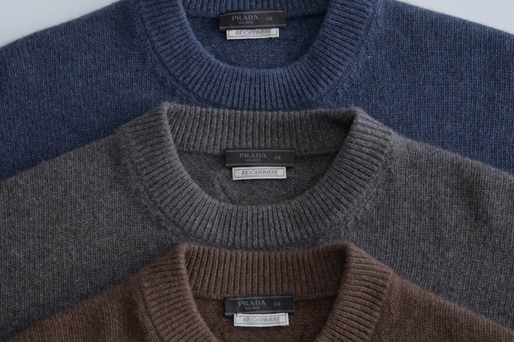Три свитера Prada Re-Cashmere стопкой: синий, серый и коричневый